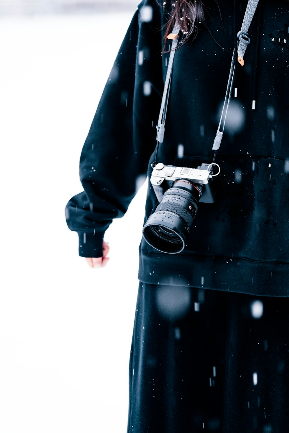 a woman holding a camera in the snow