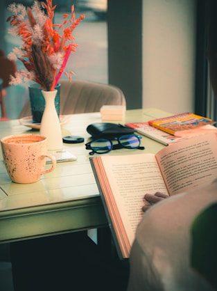 a person sitting at a table reading a book