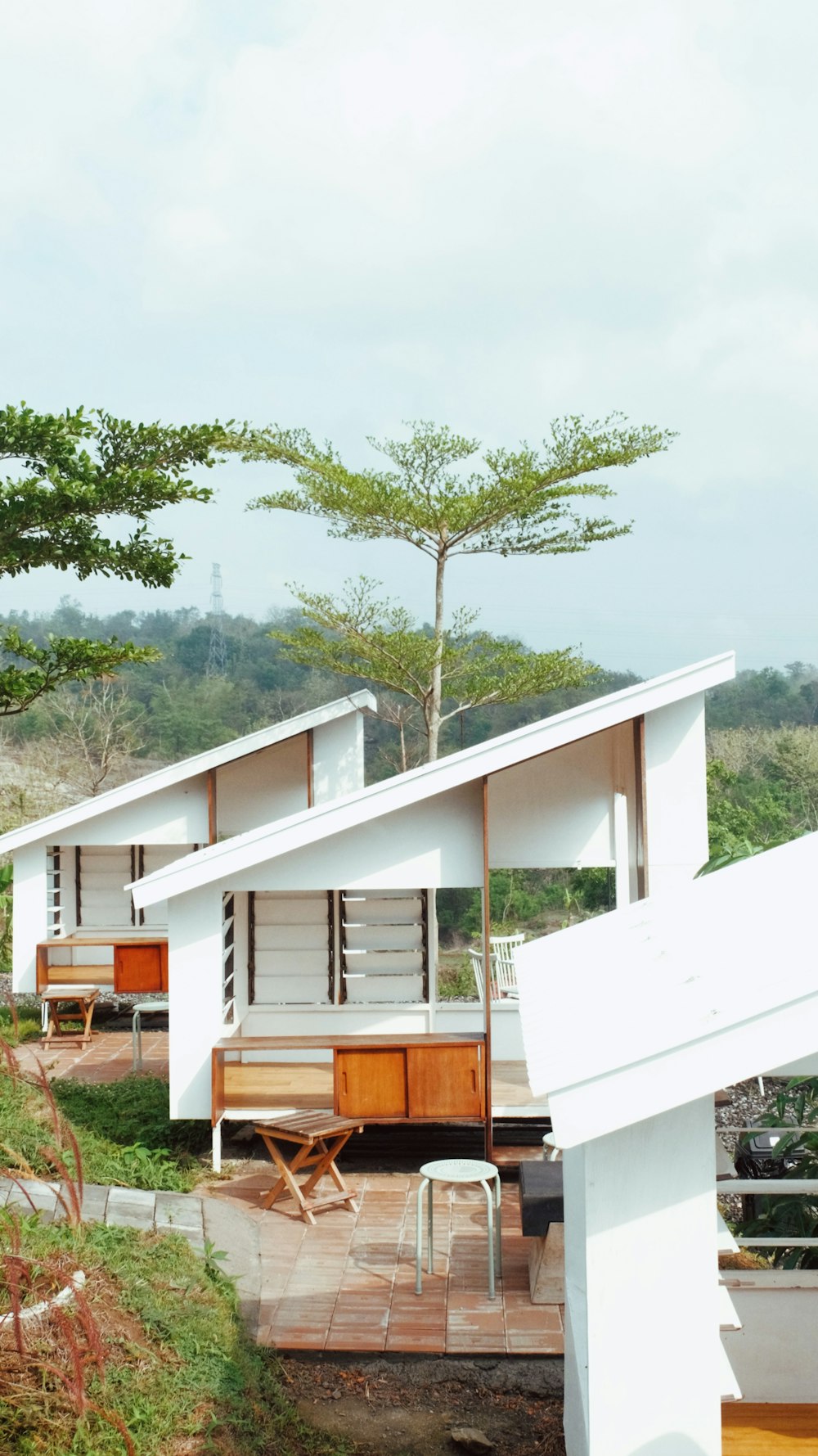 a couple of white buildings sitting on top of a lush green hillside