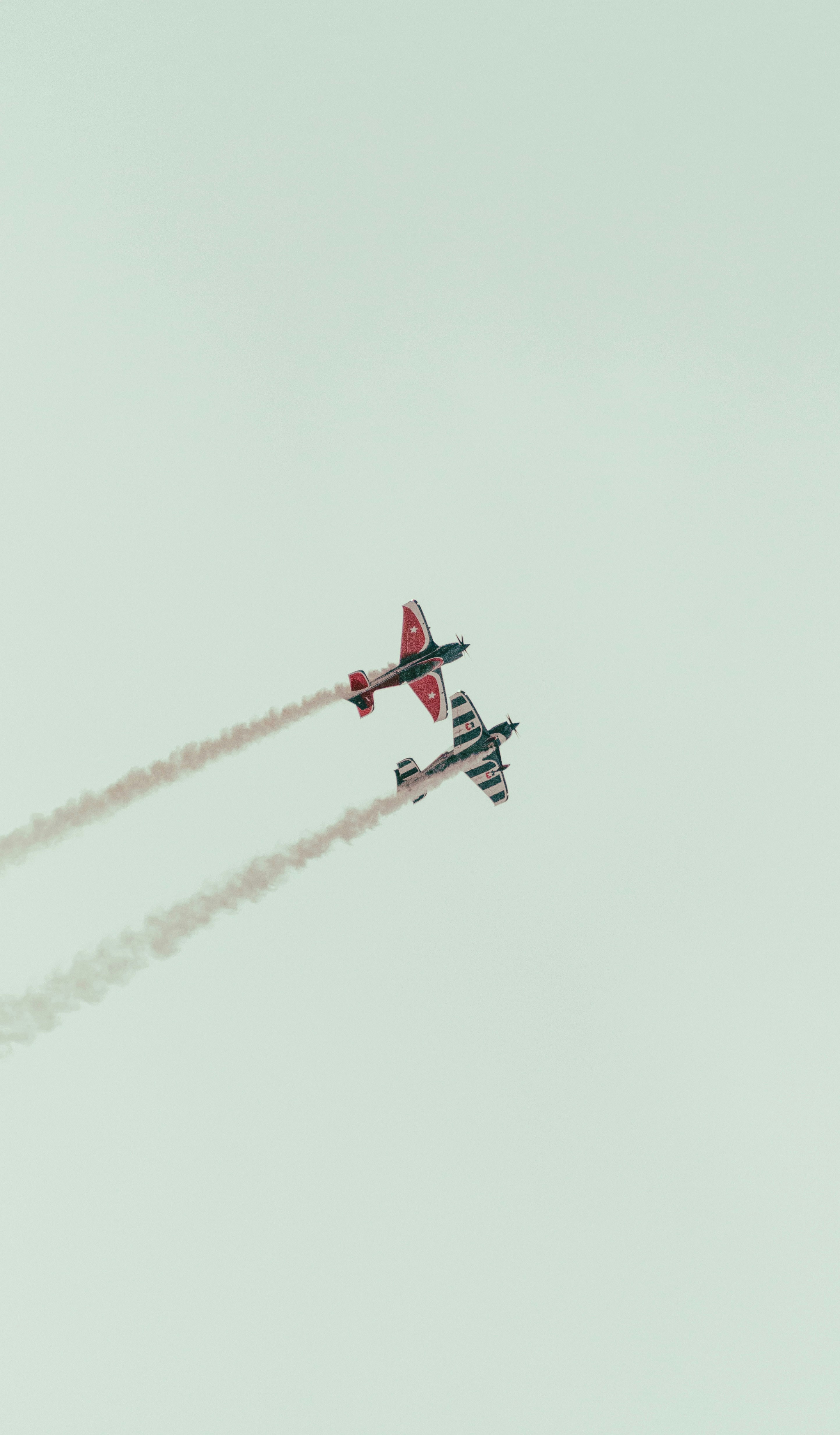 Fotomural a couple of airplanes flying through a cloudy sky