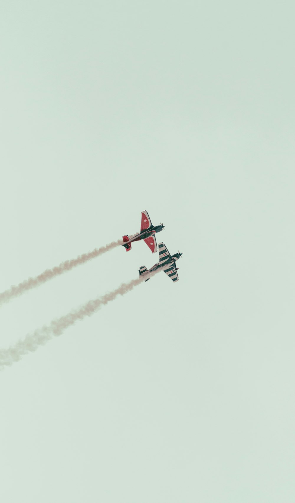 a couple of airplanes flying through a cloudy sky