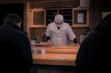 Chef El Ninja skillfully preparing sushi in the kitchen.