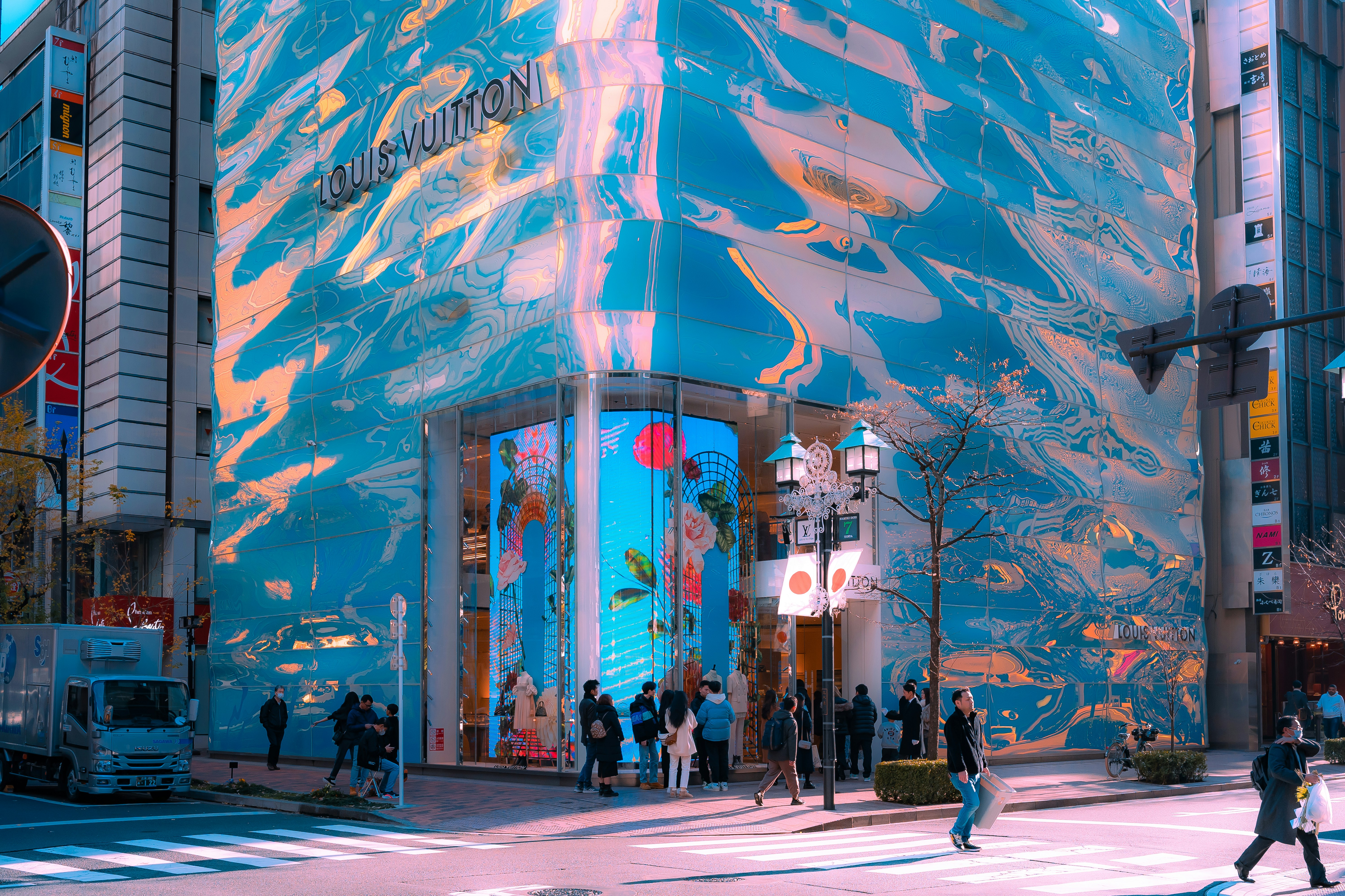 people walking on a street in front of a building