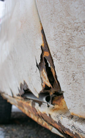 Before and after comparison of a car door showing rust removal and paint correction.