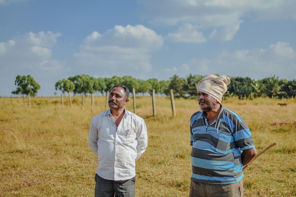a couple of men standing in a field