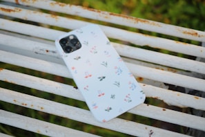 Close-up of a sleek UrbanPulse mobile resting on a graffiti-covered city bench.