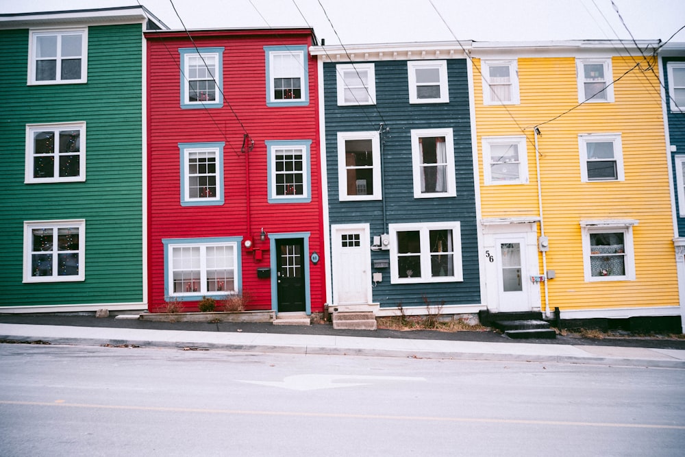 a row of multi - colored houses on a street corner