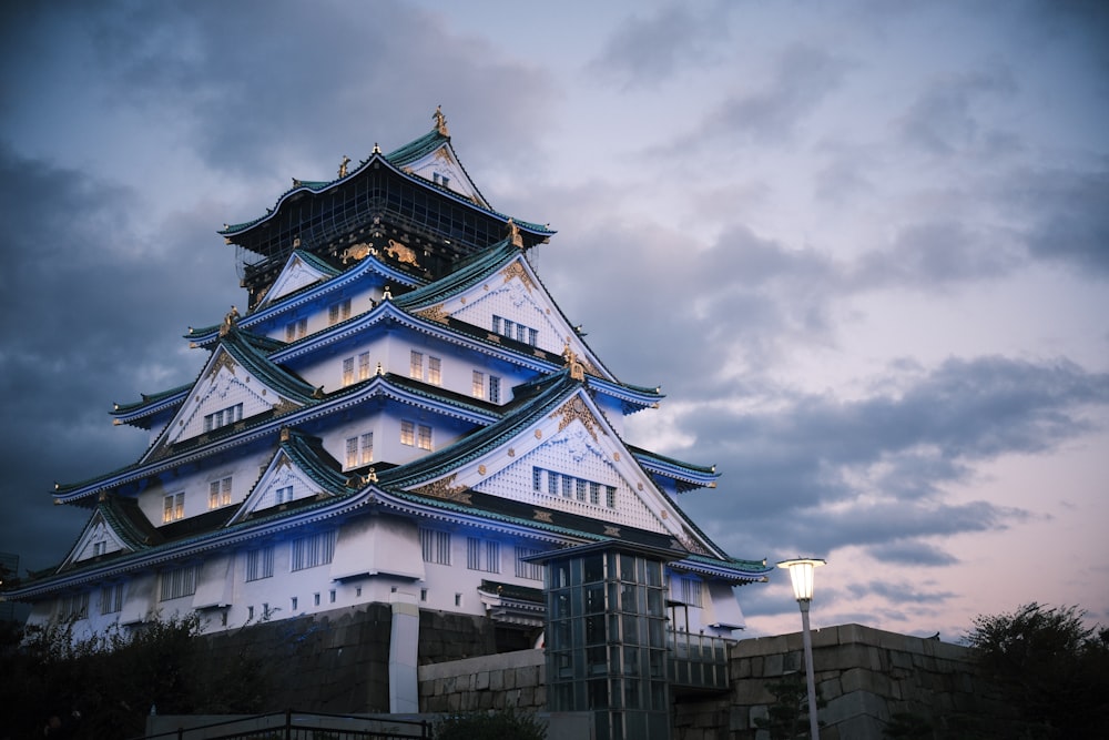 a tall white and blue building under a cloudy sky