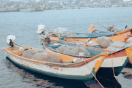 Fishing boats moored at the port of Bissau with the estuary in the background.