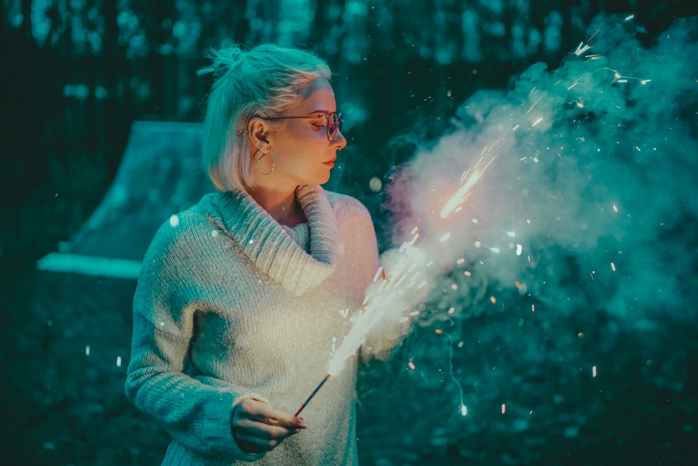 a woman holding a sparkler in her hands