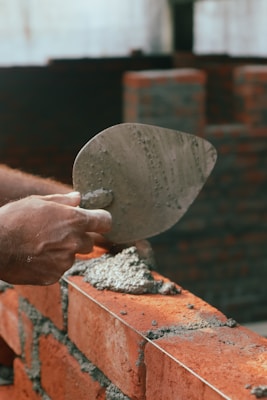 a brick wall being worked on with a trowe