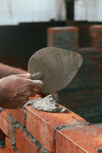 a brick wall being worked on with a trowe
