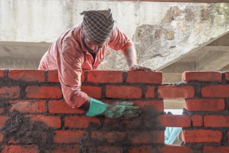 a man is working on a brick wall