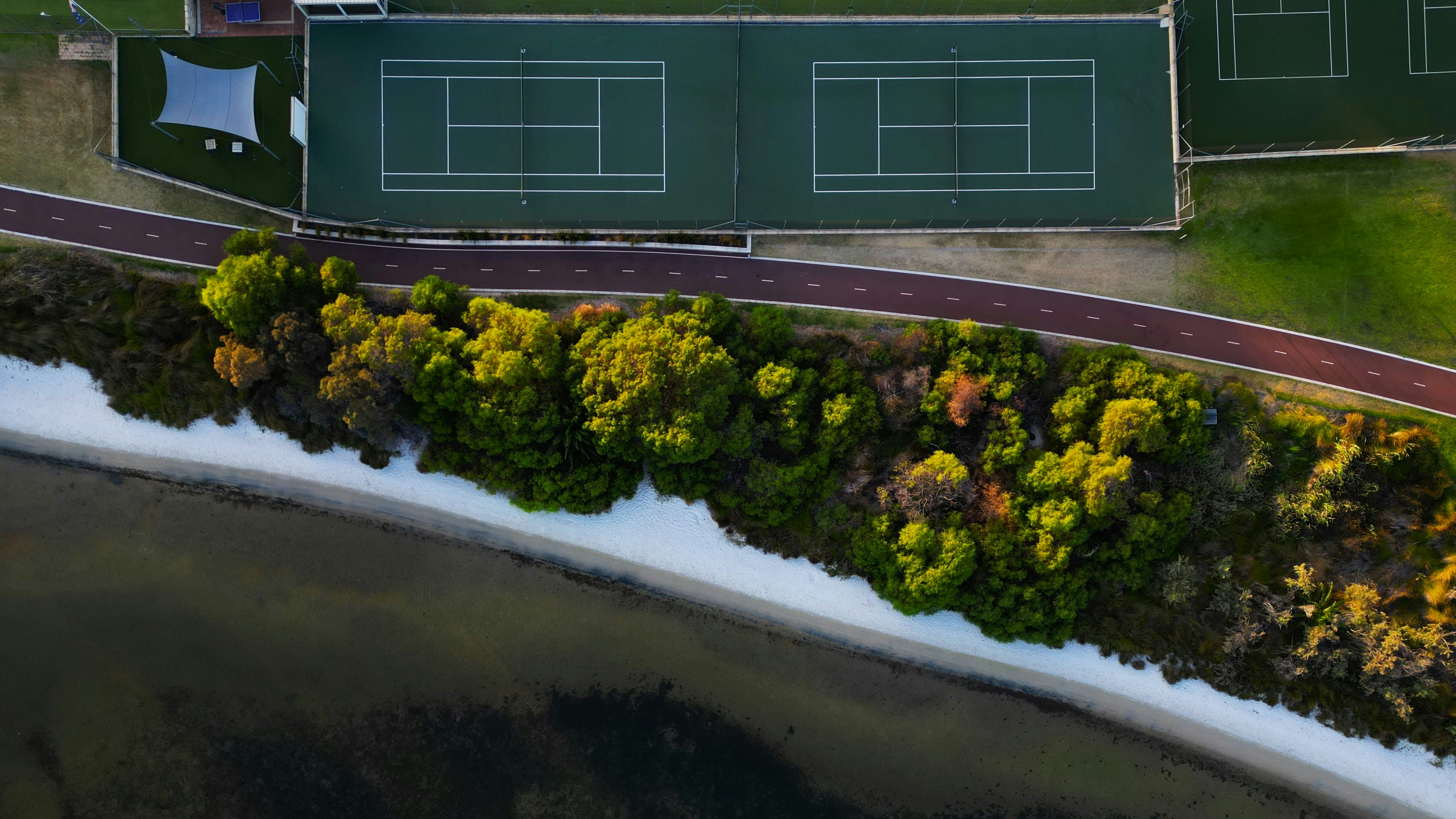 an aerial view of a tennis court surrounded by trees