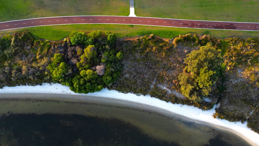 an aerial view of a road near a body of water