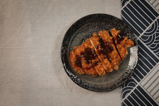 Spicy Nashville katsu bento plating with vibrant sauce and side dishes