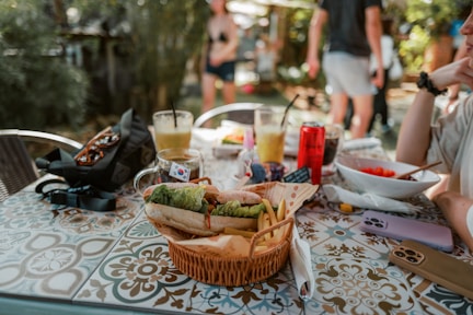a woman sitting at a table with a basket of food