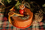 A festive cake decorated with seasonal fruits and edible gold accents.