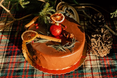 Close-up of a chocolate Christmas cake topped with glittery red and gold decorations.