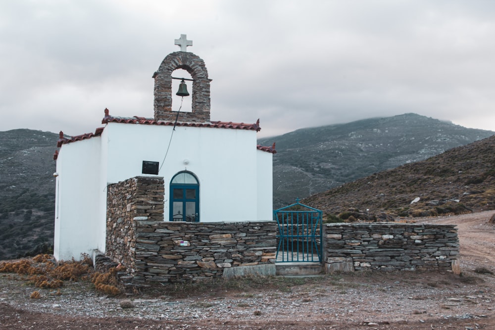 a small white church with a bell on top of it