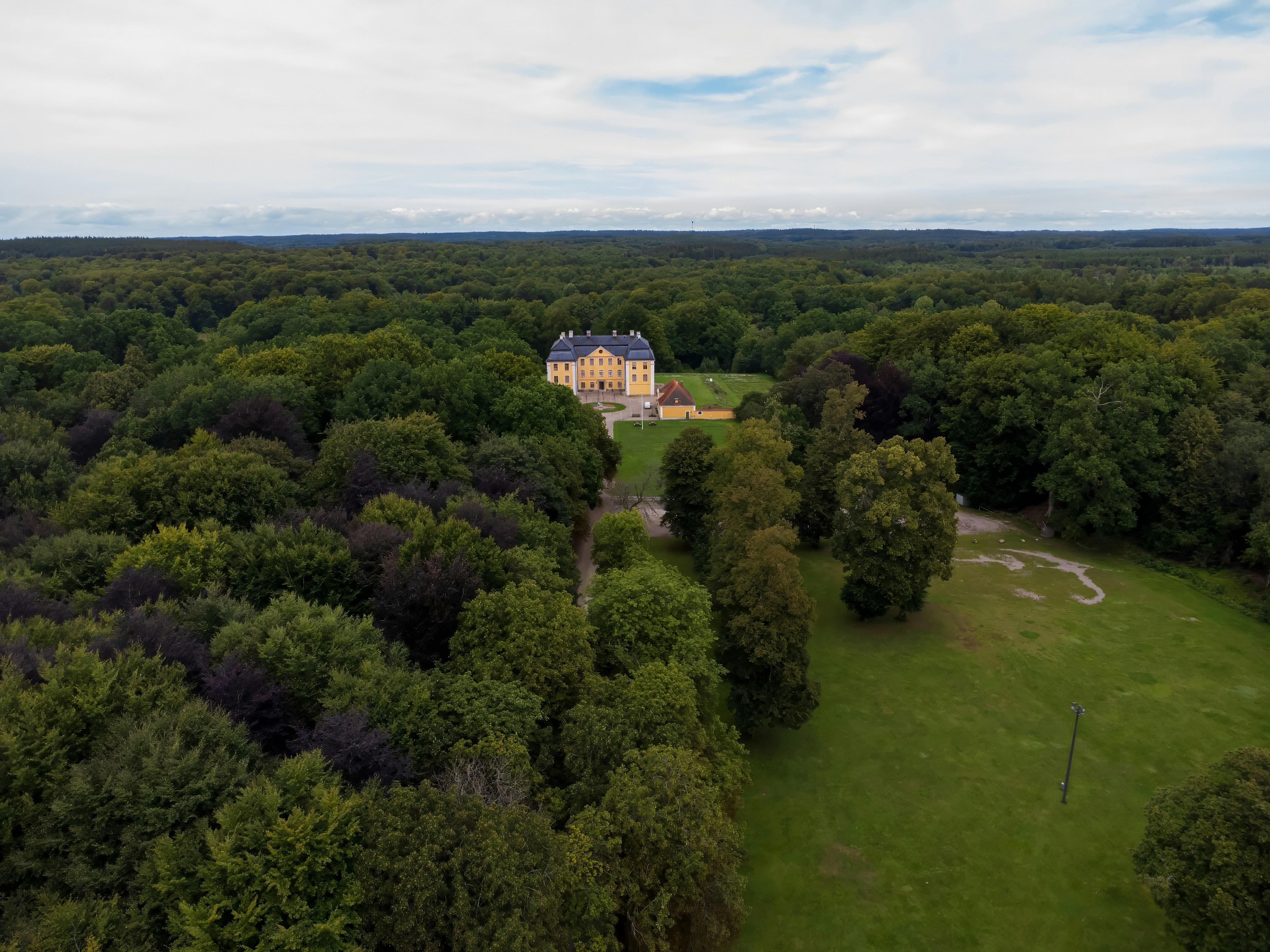 an aerial view of a large house surrounded by trees