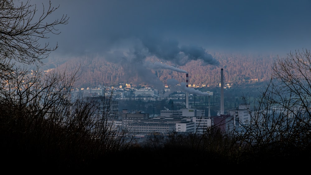 smoke billows from a factory in a city