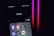 A smartphone screen displays a folder labeled 'Social,' containing icons for various social media apps, including Facebook, Instagram, Threads, X, LinkedIn, TikTok, and YouTube. The background is dark with pink and red neon lights.