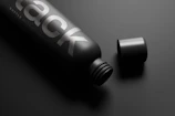 Minimalist perfume bottle with matte black finish and delicate golden details.