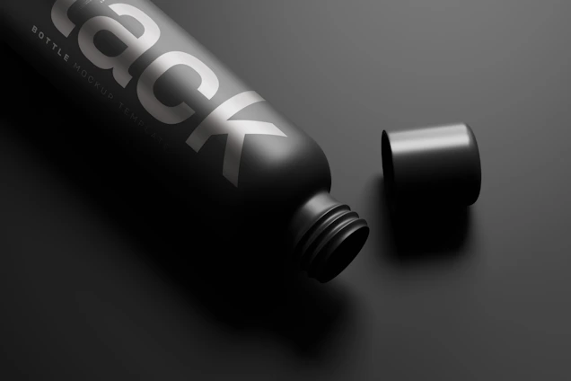 A sleek matte black magnetic bottle holding a smartphone, set against a soft pastel background.