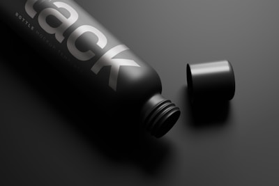 A sleek black matte bottle of Bright Citrus London Dry resting on a white surgical surface.