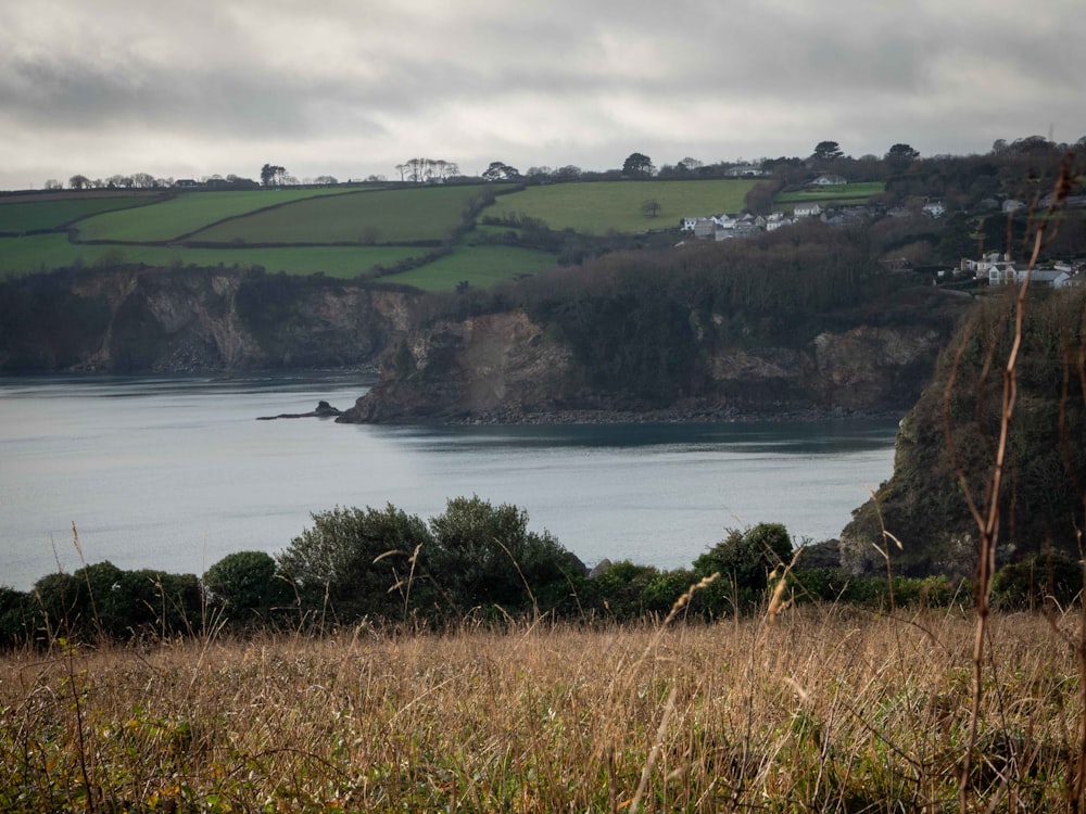 a large body of water sitting next to a lush green hillside