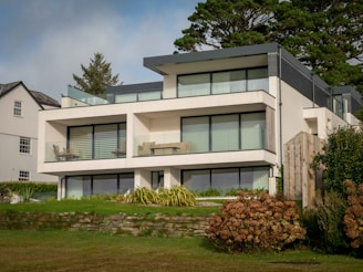 a large white house sitting on top of a lush green field