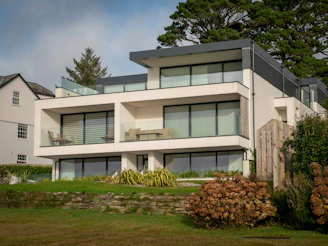 Modern two-story house with large windows and a lush green lawn in Accra.