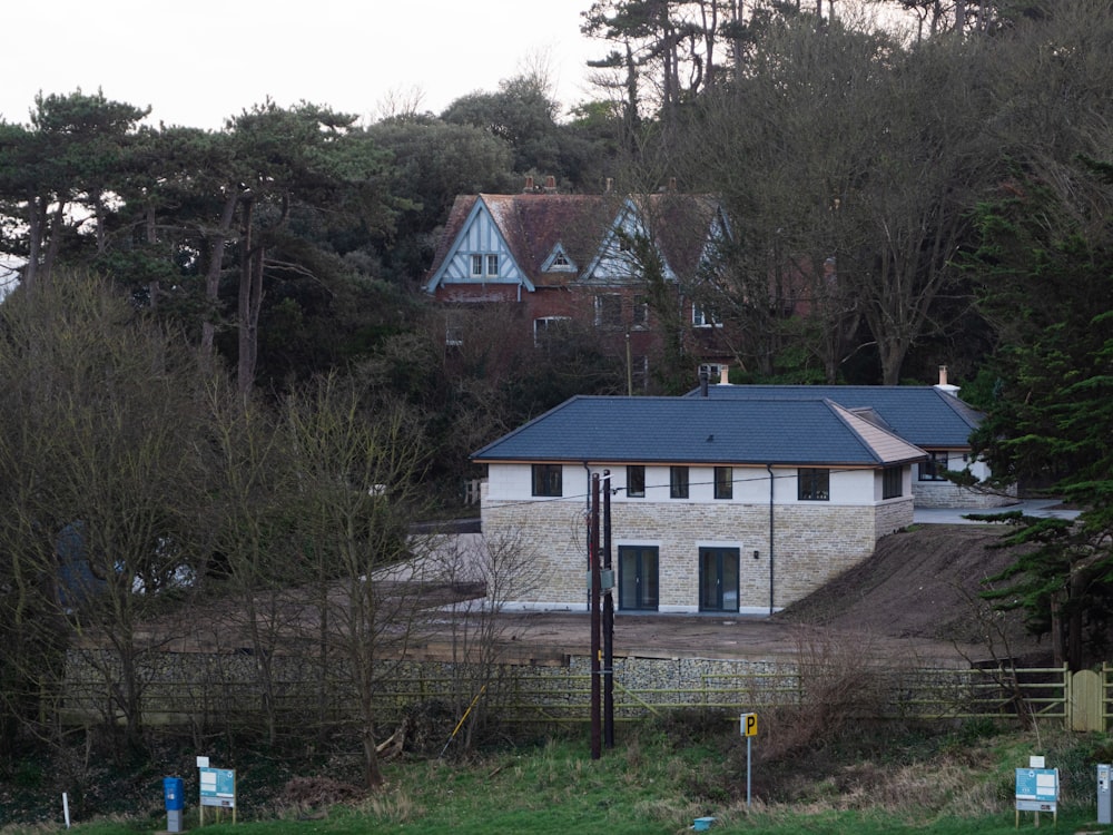 a white house with a blue roof surrounded by trees