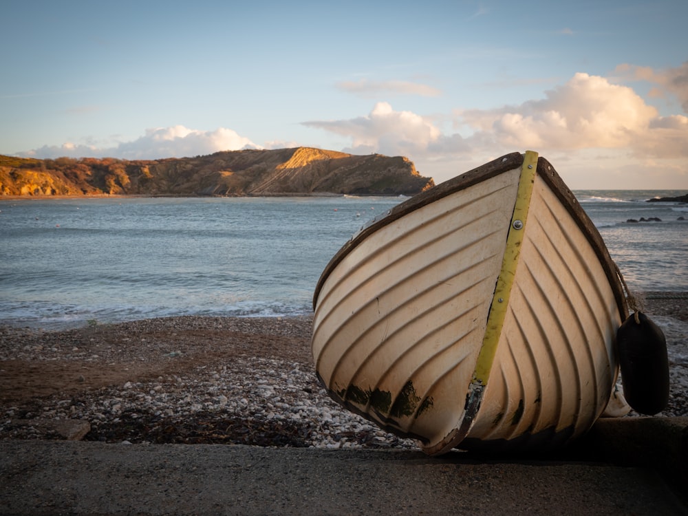 a boat sitting on top of a beach next to the ocean