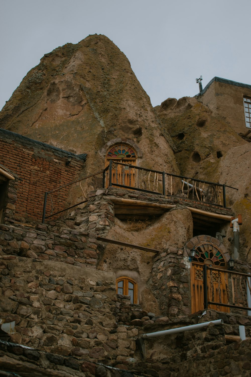 a building made of rocks with windows and balconies