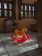 A cozy nursery corner bathed in soft morning light with plush toys and a rocking chair.