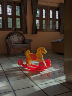 A bright, welcoming playroom with colorful cushions and natural light streaming through large windows.