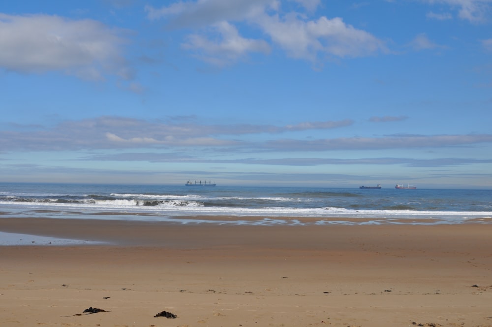 a sandy beach with a boat in the distance