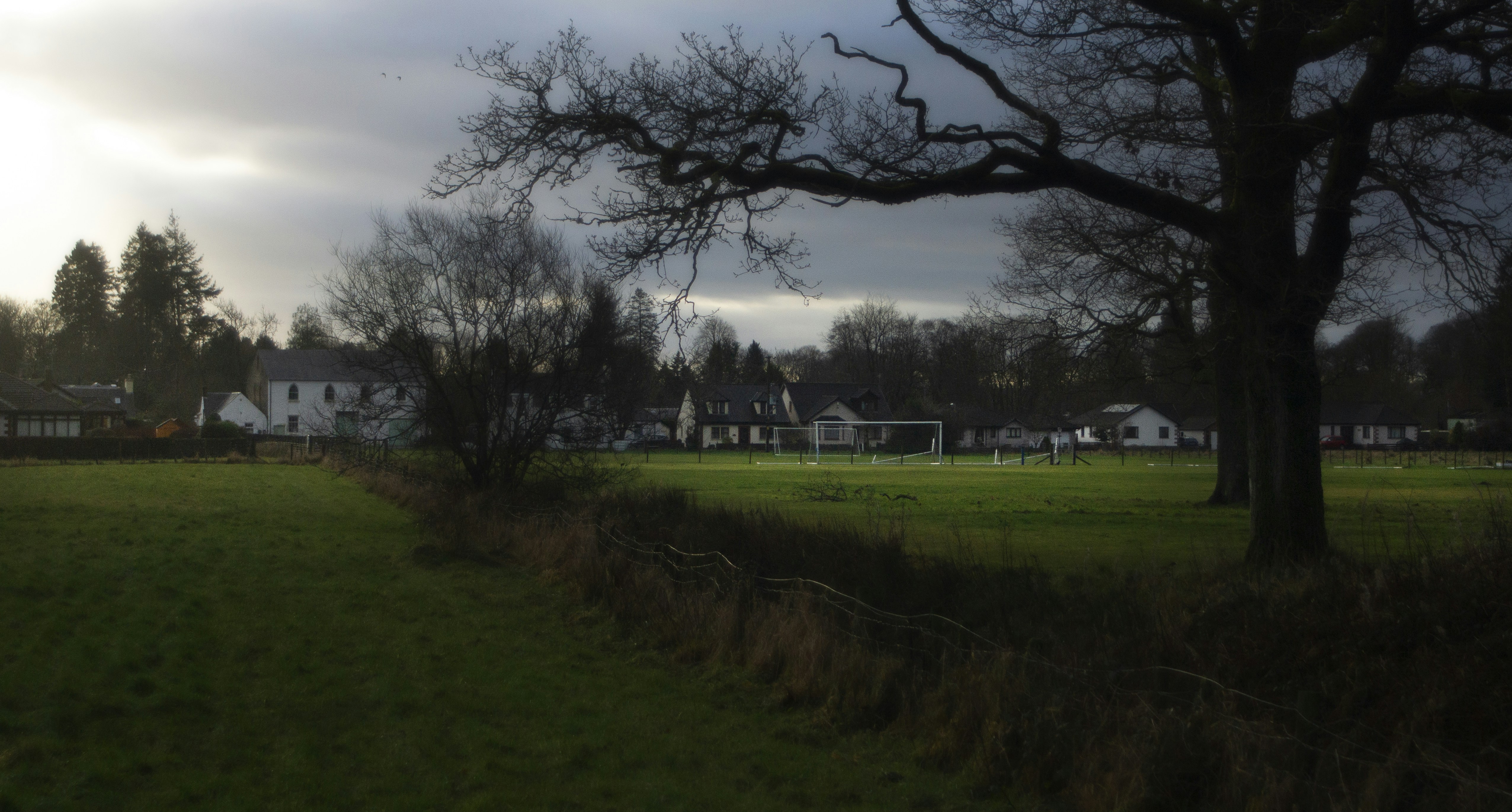 A soccer field with a soccer goal in the distance photo Free Grass