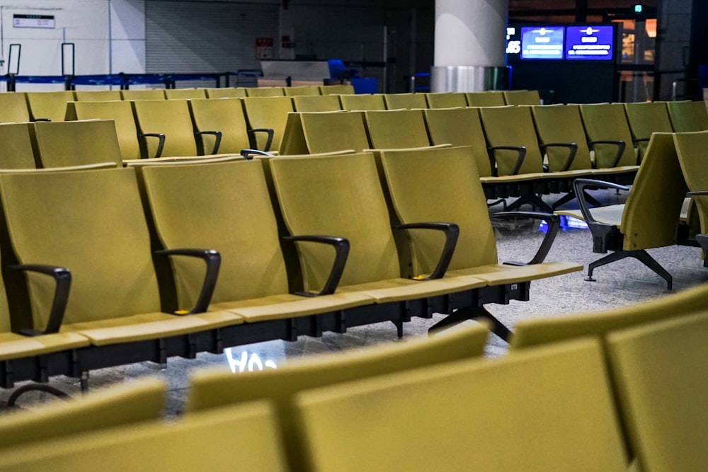 a row of empty yellow chairs in an airport