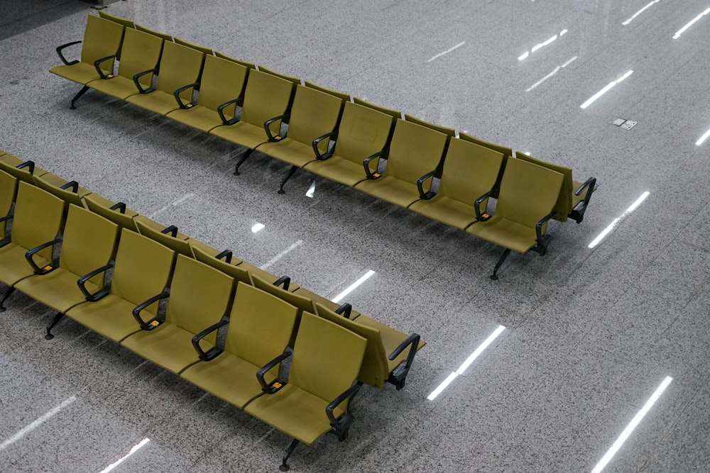 two rows of yellow chairs sitting on top of a floor