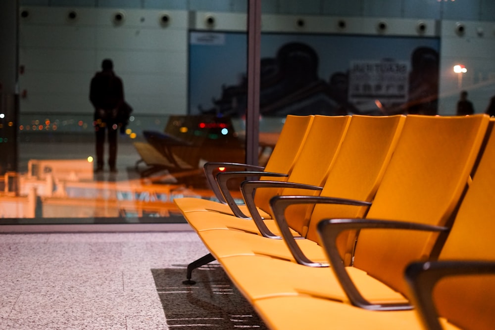 a row of yellow chairs sitting on top of a floor