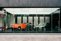 a reflection of a car and a motorcycle in a window