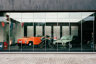 a reflection of a car and a motorcycle in a window