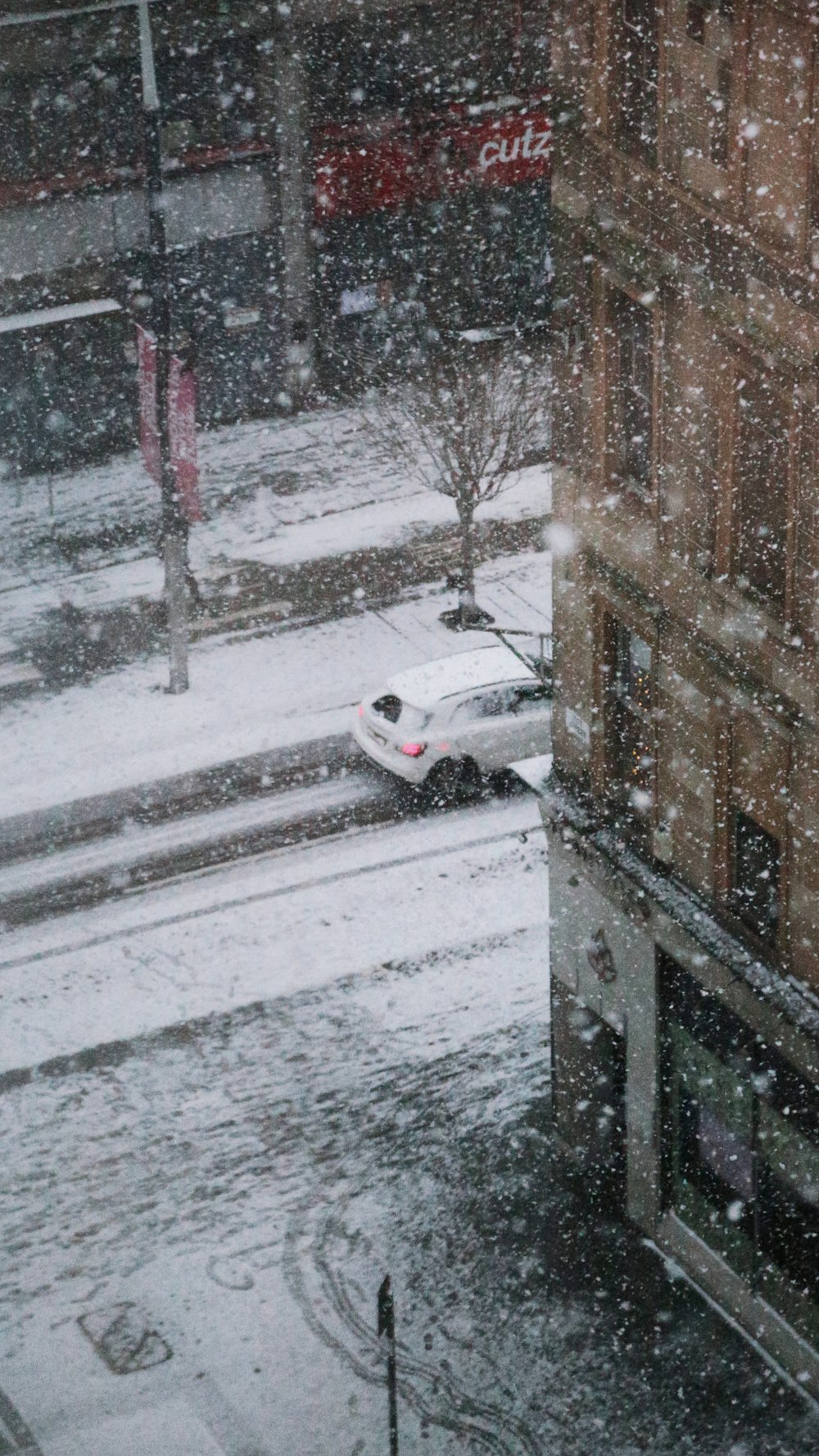 Un coche está aparcado en una calle nevada