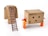 Two toy figures are interacting with a large cardboard box that has the appearance of a robot with a simple face drawn on it. The box stands on four small legs, resembling a character with arms. A brown ladder is placed on another cardboard box figure, leaning against it. The figures appear to be in a playful setting, using everyday objects creatively.