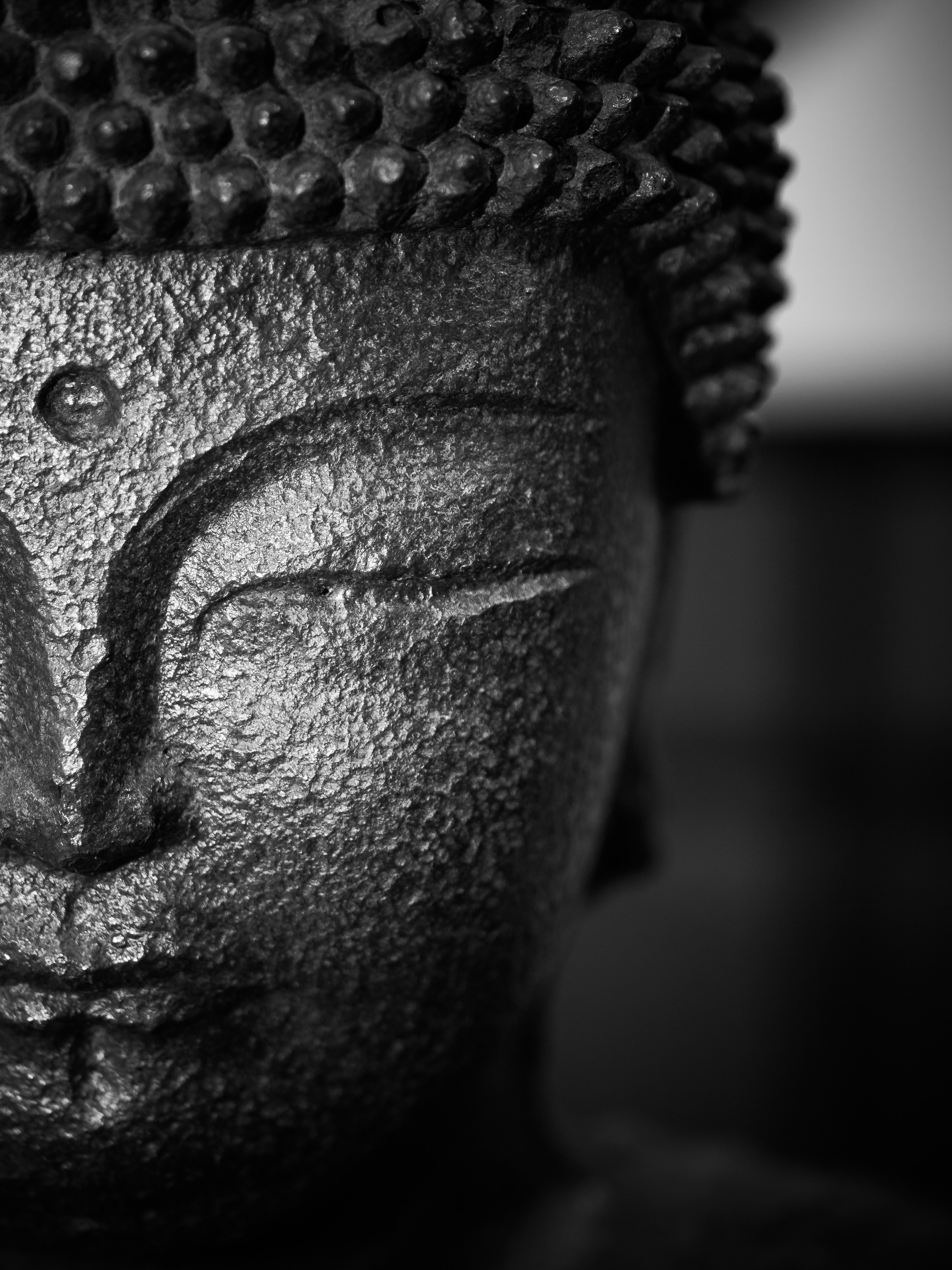 a black and white photo of a Buddha statue