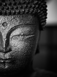 a black and white photo of a buddha statue