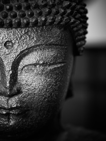 a black and white photo of a buddha statue
